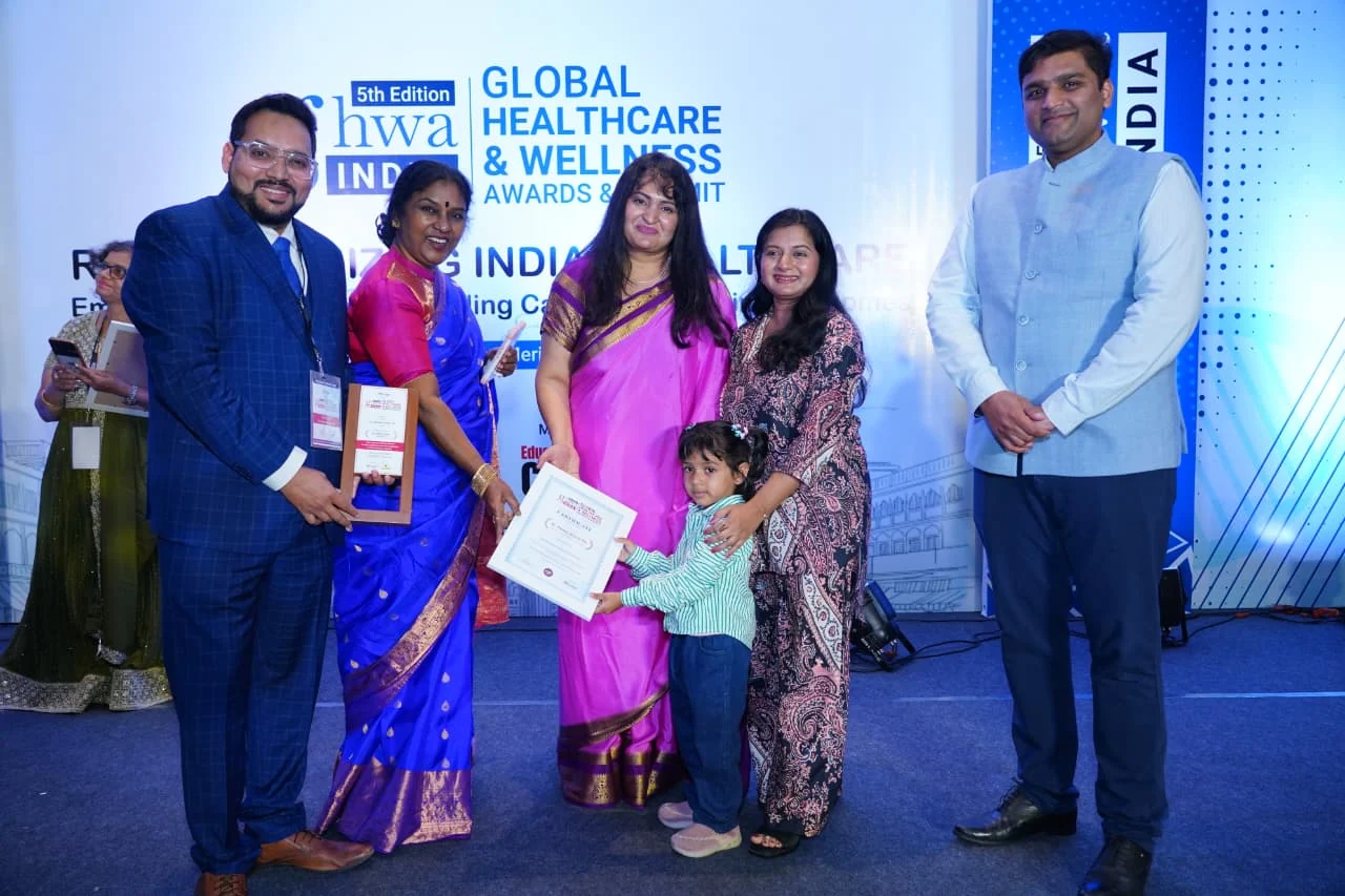 Dr. Ashwin Kumar Pal with family and event guests at an awards stage
