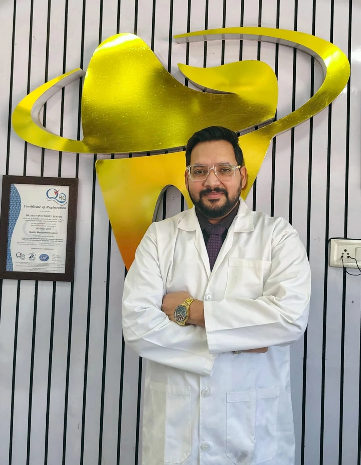 Dr. Ashwin Kumar Pal standing in front of the clinic logo